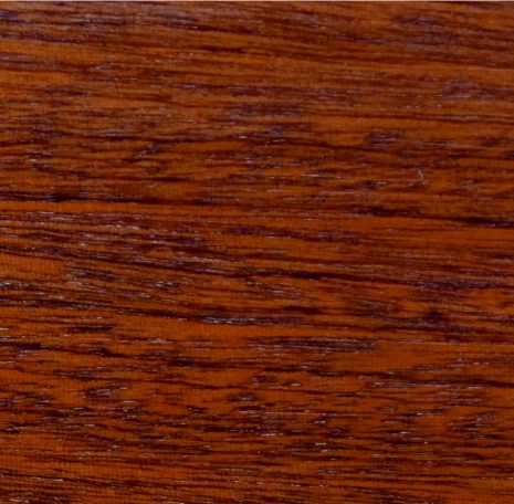 A close-up of a rich, warm wood grain texture in reddish-brown tones.